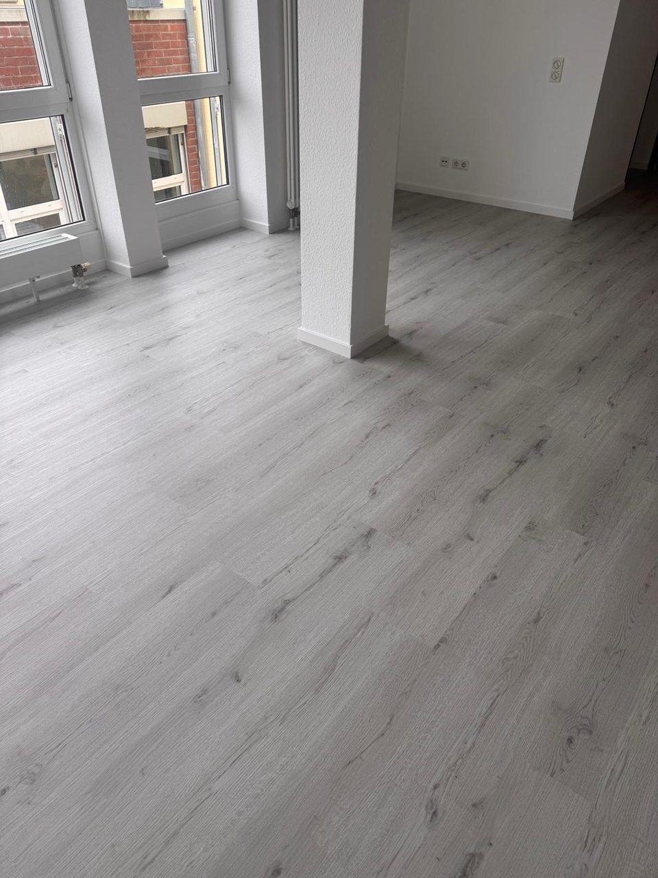 Klick-Vinyl in heller Eichenoptik vor bodentiefen Fenstern – Projekt von Kühn Bodenbeläge